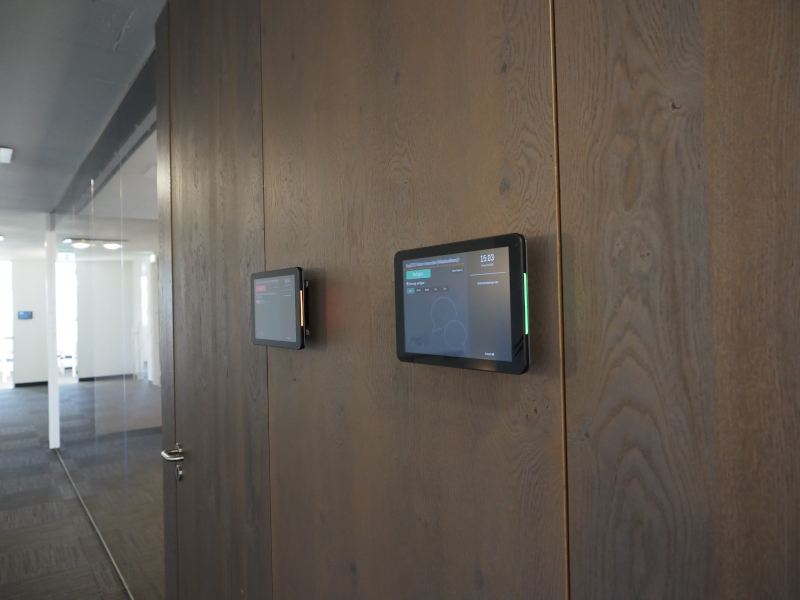 A Roombelt display mounted beside a meeting room door in an office